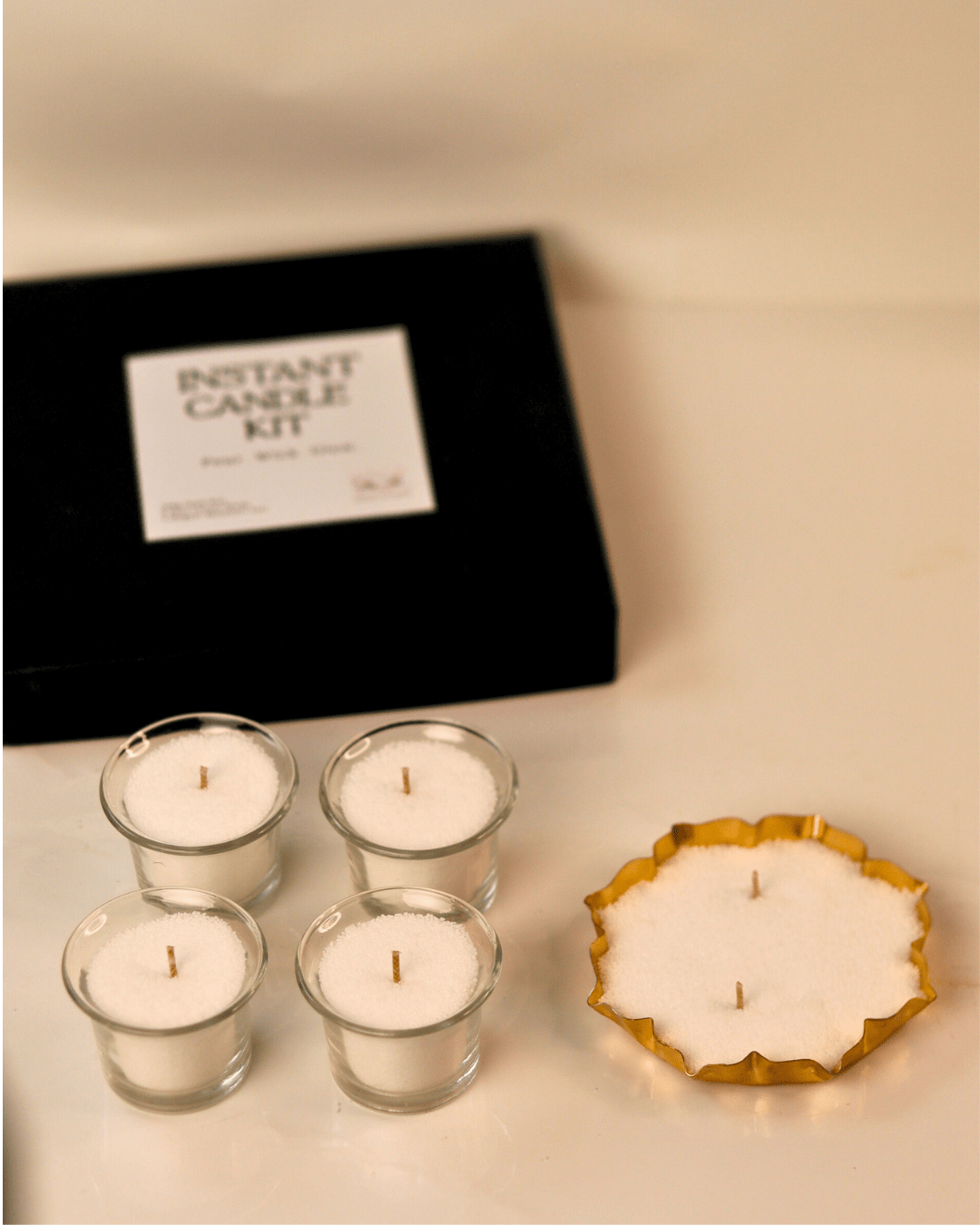 Instant candle kit with four small candles and a decorative candle on a neutral background